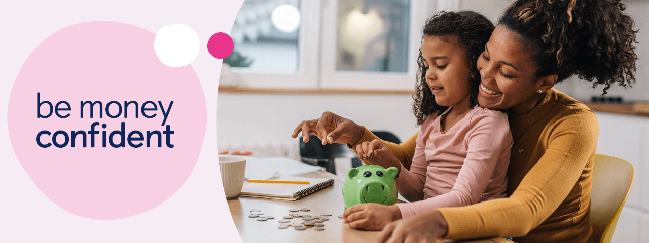 Child sat on parents lap placing coins in a piggy bank