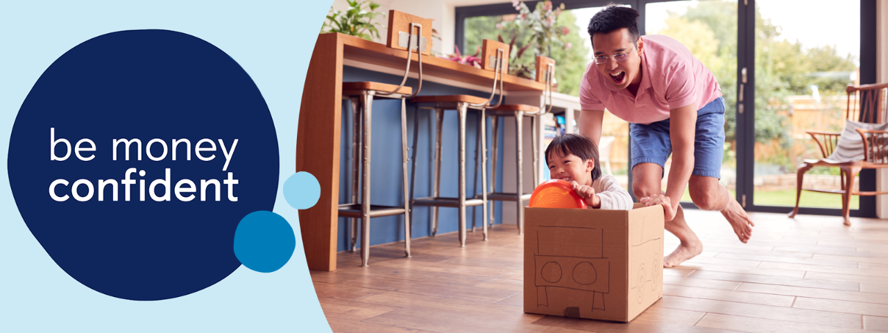 Adult pushing a child along the floor in a carboard car