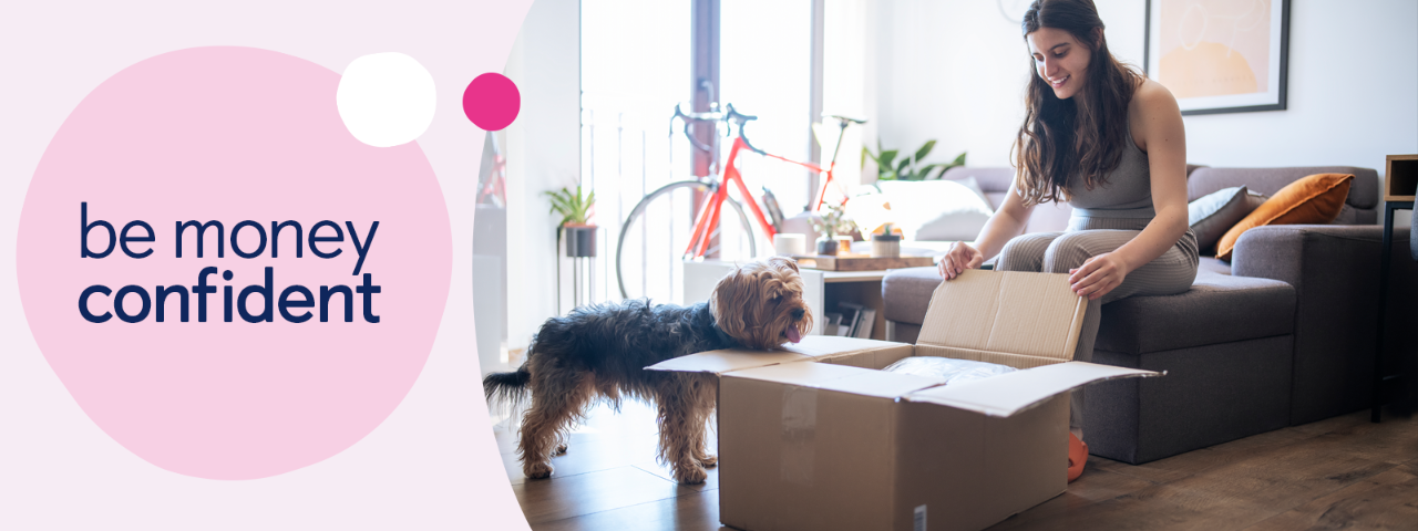 Person packing a moving box with dog and bike in the background