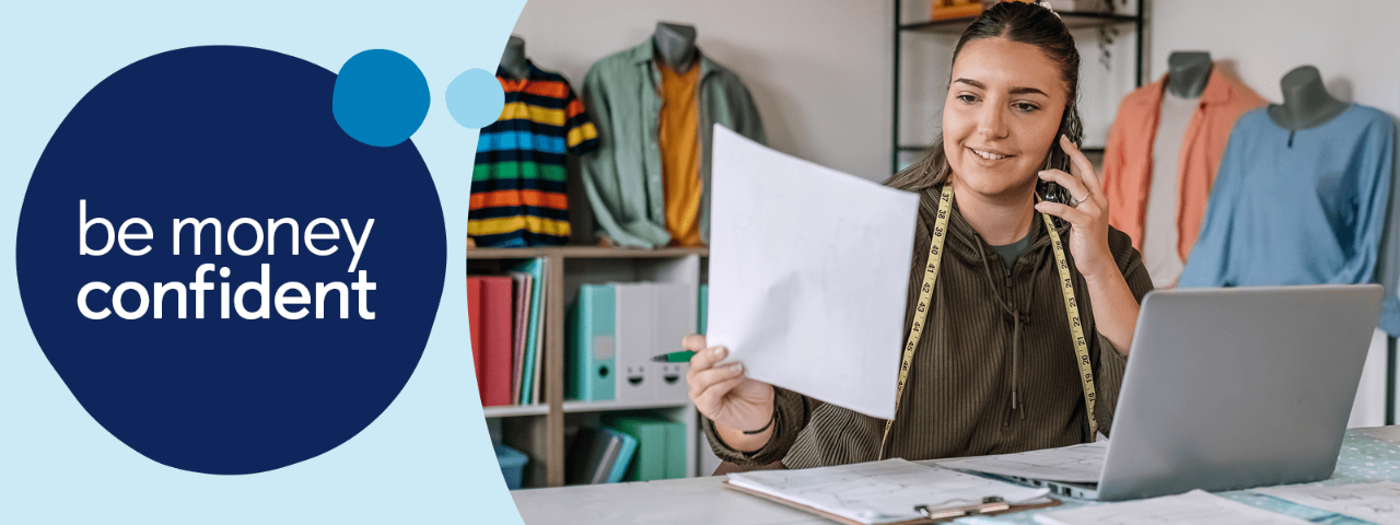 Person on phone with laptop looking at document